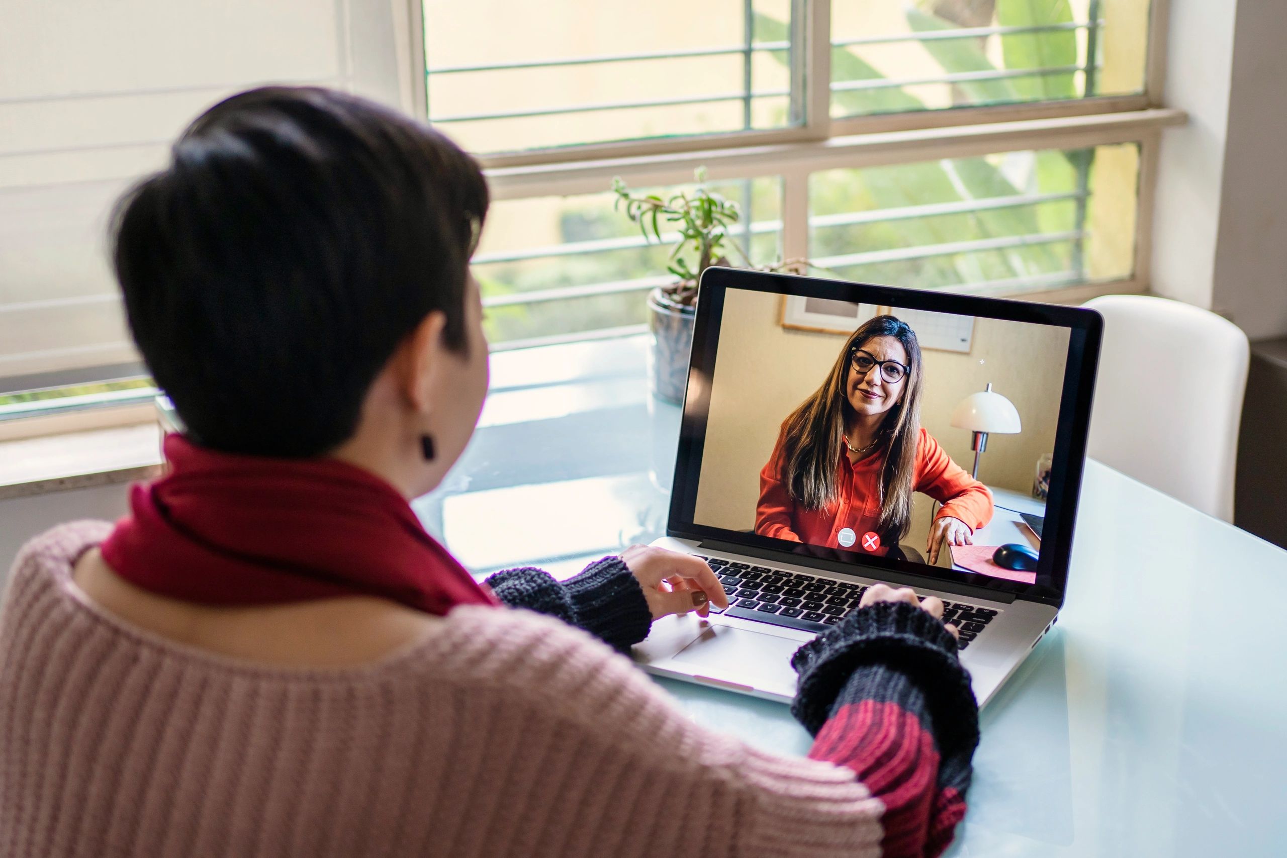 Person in a telehealth video session on a laptop